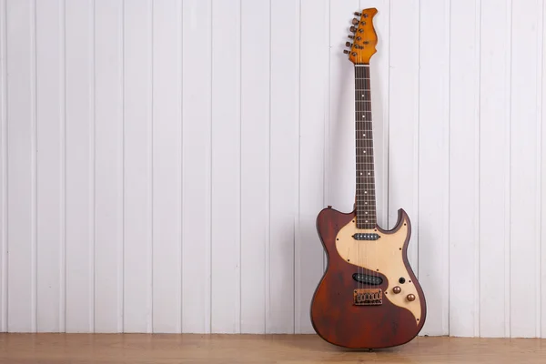 Guitarra eléctrica sobre fondo de pared de madera blanca — Foto de Stock