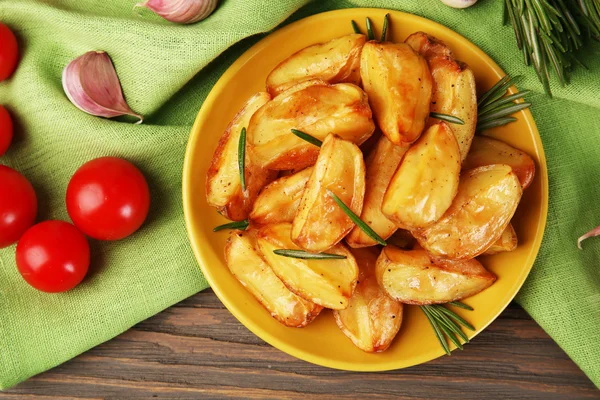 Cunhas de batata assadas na mesa de madeira, vista superior — Fotografia de Stock