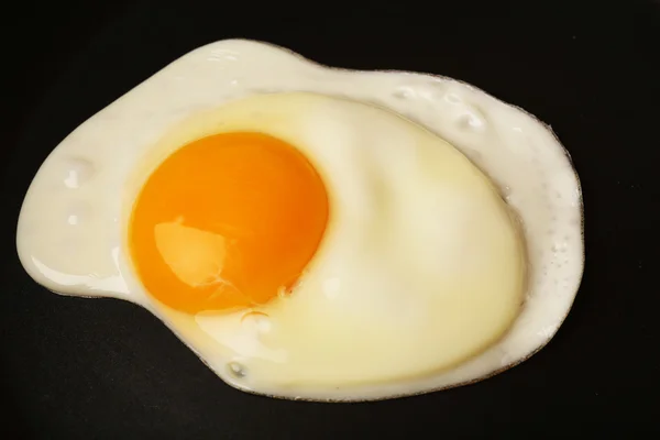 Scrambled egg on black pan background — Stock Photo, Image