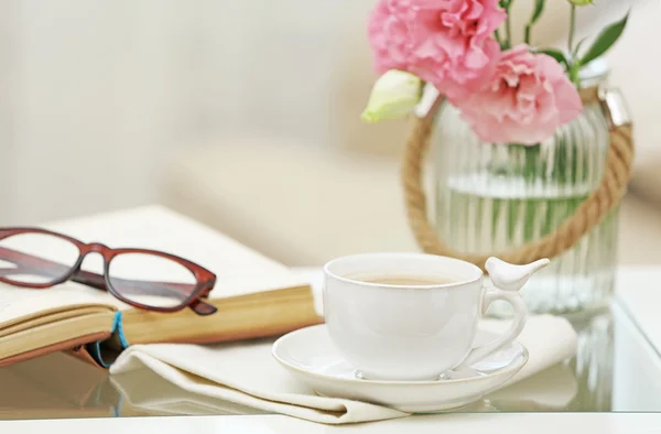 Xícara de café com livro na mesa na sala de estar — Fotografia de Stock