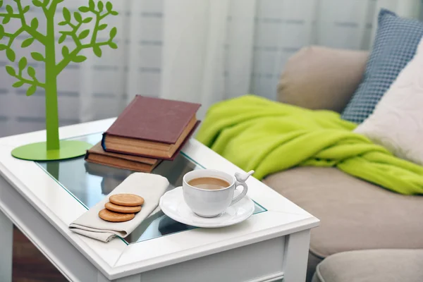 Cup of coffee with books on table in living room — Stock Photo, Image
