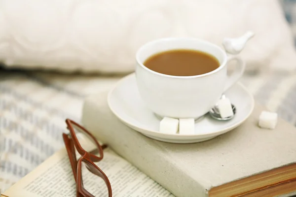 Cup of coffee with books on sofa in living room — Stock Photo, Image