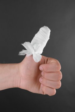 Koyu arka plan üzerinde yaralı bandajlı parmak
