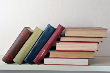 Eski kitaplar raf, yakın çekim, ışık duvar arka plan üzerinde
