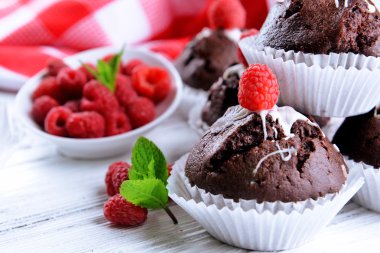Çilek ve ahşap masa üzerinde taze nane ile lezzetli çikolata cupcakes yakın çekim