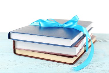 Tablo üzerinde beyaz izole kurdele ile kitap yığını