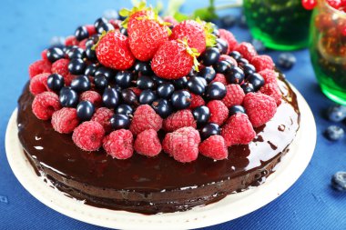 Mavi masa örtüsü, closeup üzerinde yaz meyveleri lezzetli çikolatalı kek