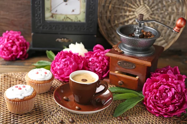 Tasse Kaffee und Pfingstrosenblüten — Stockfoto