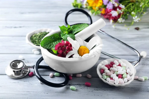 Alternatieve geneeskunde kruiden en stethoscoop op houten tafel achtergrond — Stockfoto