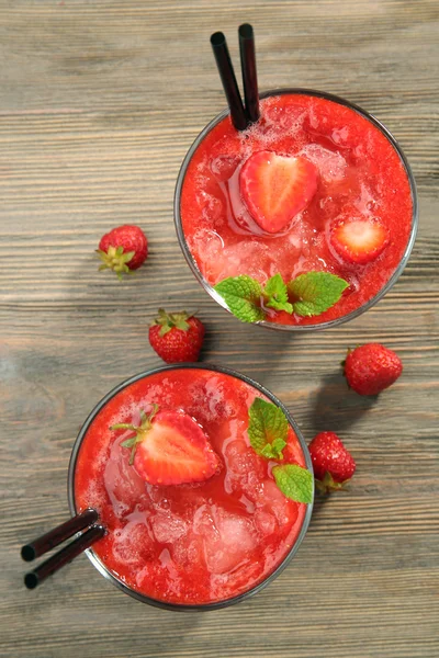 Glasses of strawberry smoothie with berries on table close up — Stock Photo, Image