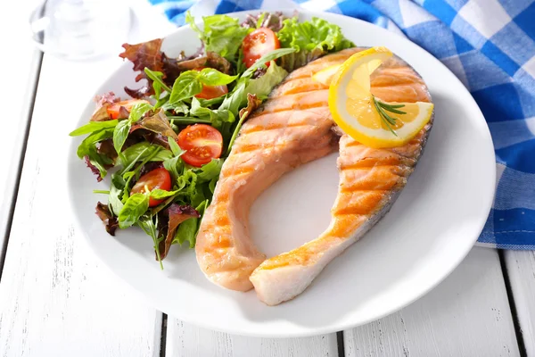 Tasty grilled salmon with salad on table close up — Stock Photo, Image