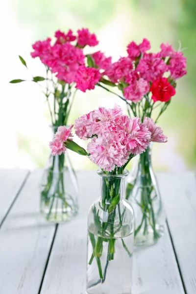 Beautiful bouquet of pink carnation in vases on bright background — Stock Photo, Image