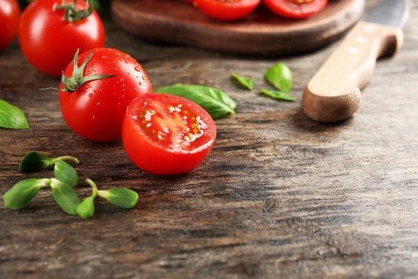 Kerstomaten met basilicum op houten tafel close up — Stockfoto