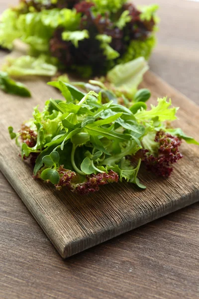 Ahşap masa üzerinde taze karışık yeşil salata tabak kapat — Stok fotoğraf