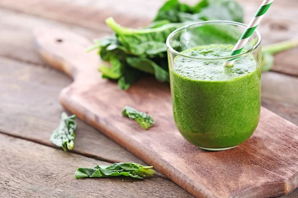Glass of spinach juice on wooden table, closeup — Stock Photo, Image