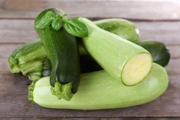 Fresh zucchini with squash and basil on wooden table close up — Stock Photo, Image