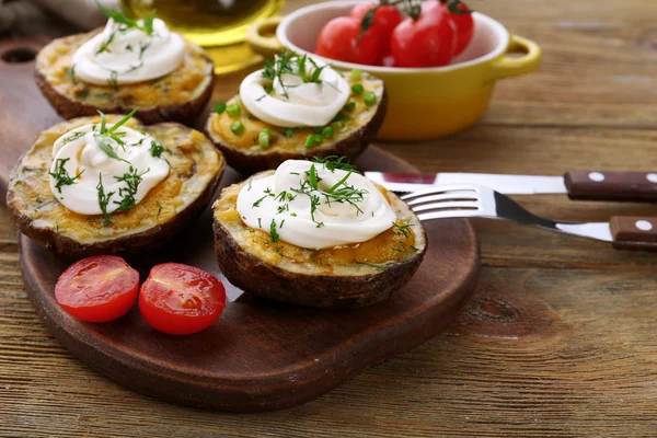 Patata al horno con mayonesa y hierbas en tabla de cortar de madera, primer plano —  Fotos de Stock
