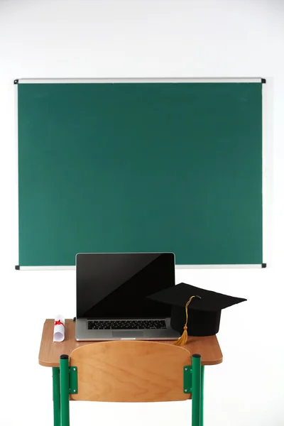 School Bureau met laptop, master hoed en diploma in klas — Stockfoto