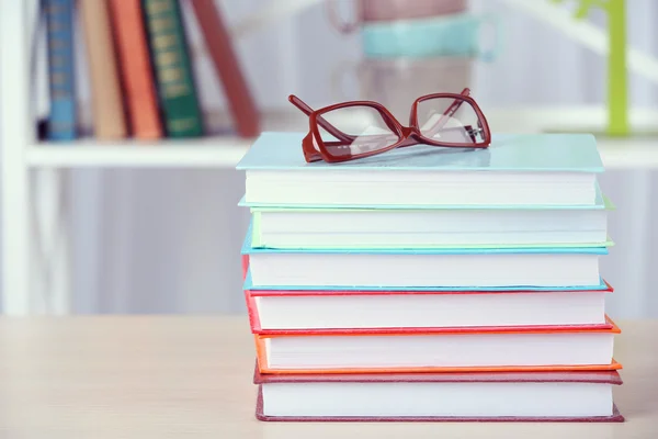 Masada gözlüklü bir yığın kitap. — Stok fotoğraf