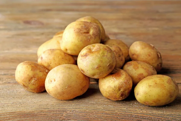 Молода картопля на дерев'яному столі крупним планом — стокове фото