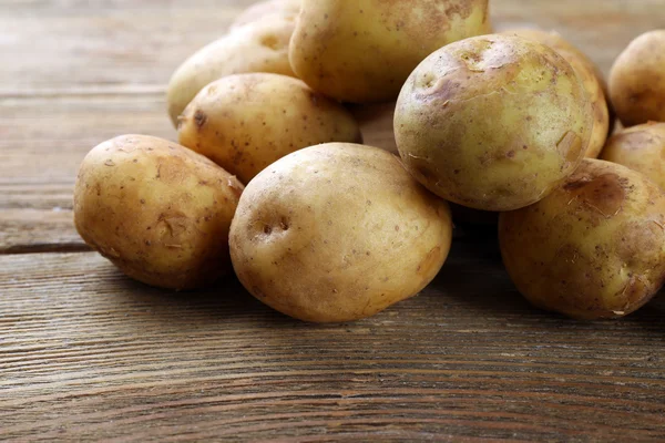 Batatas jovens na mesa de madeira perto — Fotografia de Stock