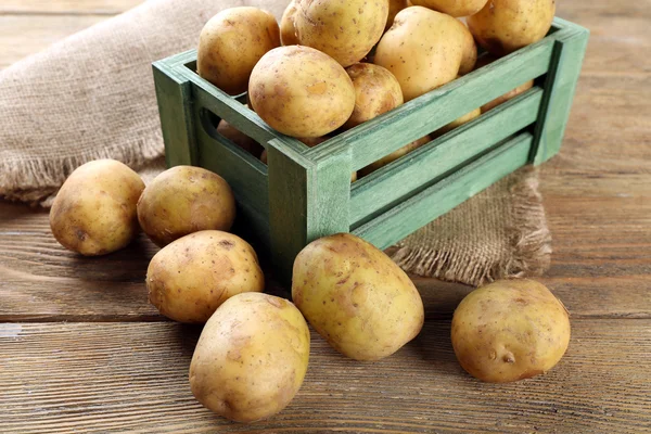 Jonge aardappelen in krat op tafel close-up — Stockfoto