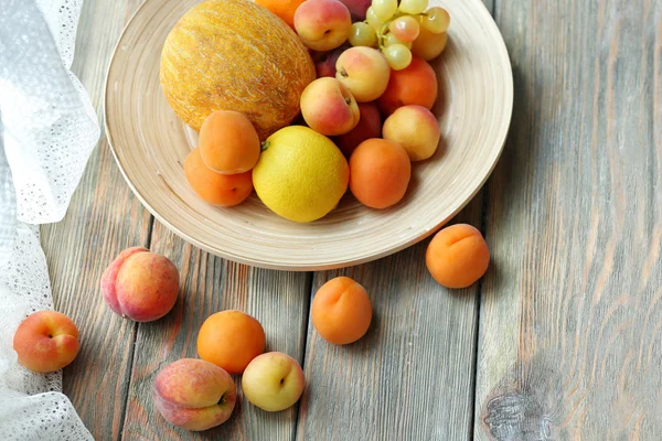 Haufen frischer Früchte auf Tablett auf Holztisch in Großaufnahme — Stockfoto