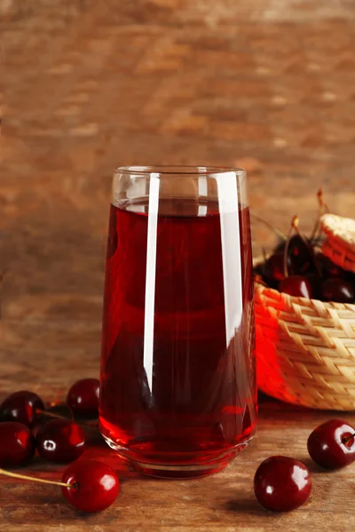 Glass of cherry juice on wooden background — Stock Photo, Image