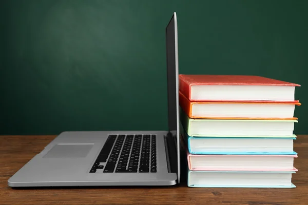 Montón de libros con portátil en la mesa en el aula —  Fotos de Stock