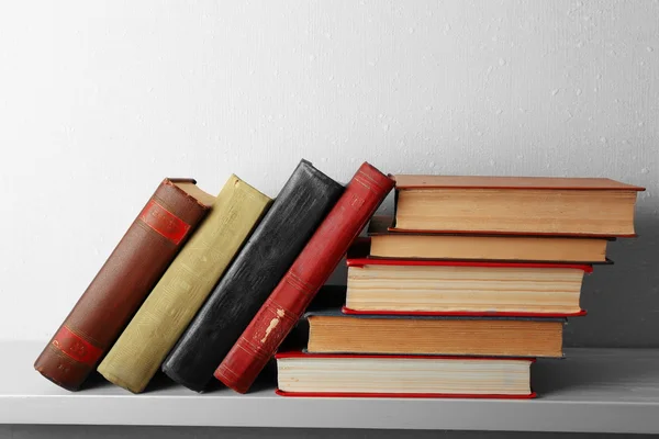 Oude boeken op plank, close-up, op lichte muur achtergrond — Stockfoto