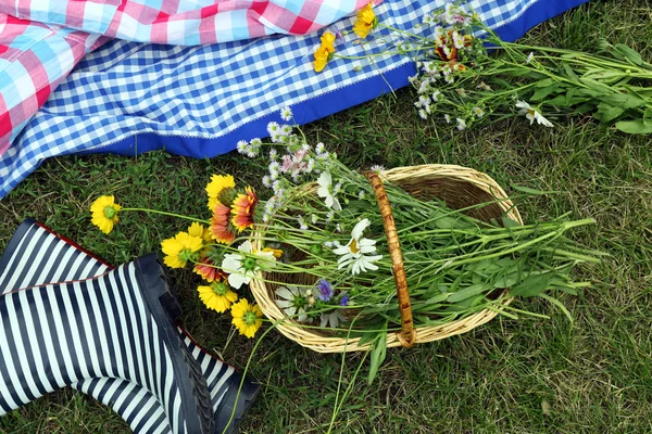 Bouquet of wild flowers and rubber boots — Stock Photo, Image