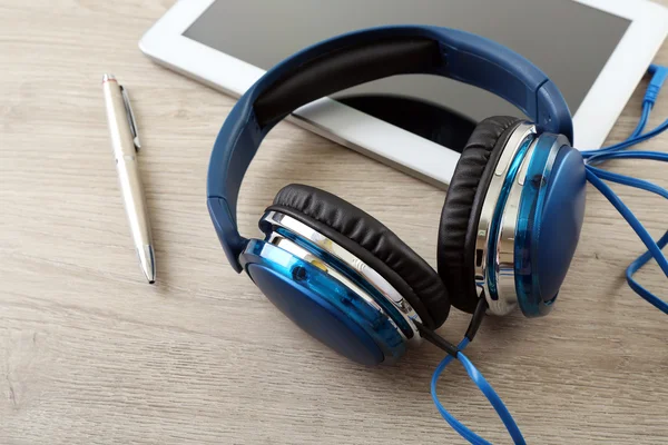 Auriculares con tablet en mesa de madera de cerca —  Fotos de Stock