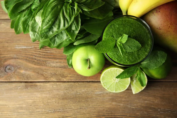 Jus hijau sehat dengan buah-buahan dan tanaman herbal di meja kayu tutup — Stok Foto