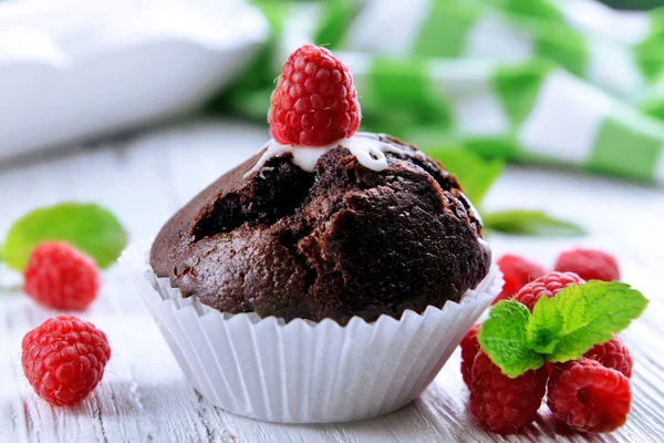 Delicioso cupcake de chocolate con bayas en la mesa de madera de cerca — Foto de Stock