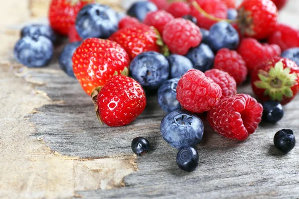 Heap of sweet tasty berries on wooden table close up — Stock Photo, Image