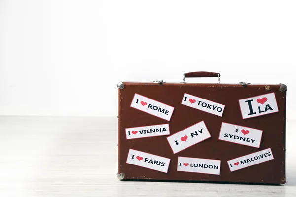 Suitcase with stickers on floor — Stock Photo, Image