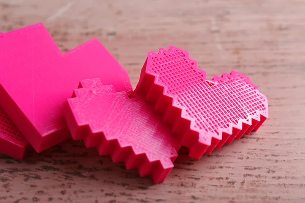 Plastic hearts on wooden table — Stock Photo, Image