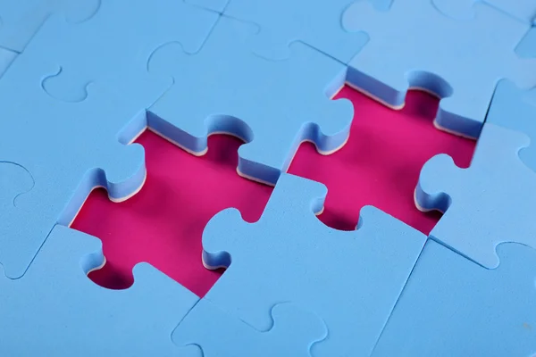 Missing puzzle pieces on pink surface, closeup — Stock Photo, Image