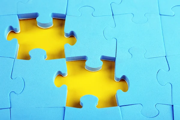 Missing puzzle pieces on yellow surface, closeup — Stock Photo, Image