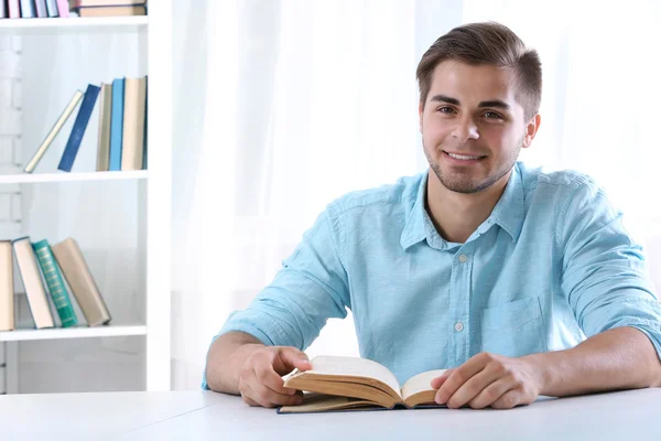 Giovane lettura libro a tavola — Foto Stock