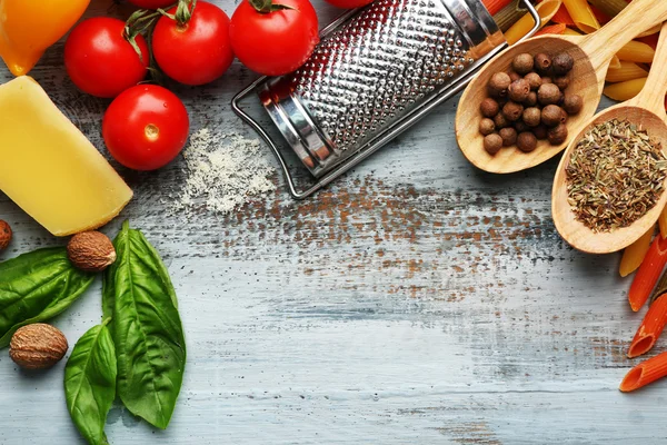 Penne de pasta con tomates, queso y albahaca sobre fondo de madera de color — Foto de Stock