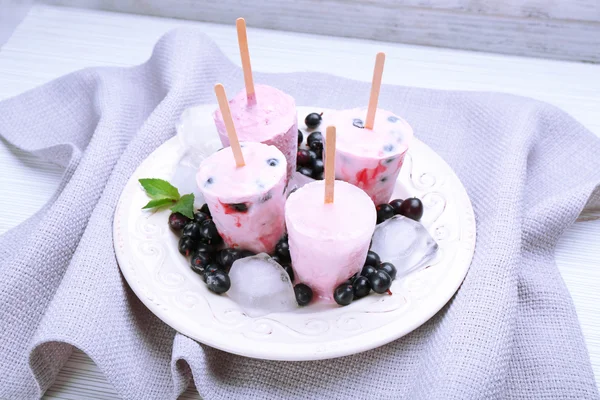 Sweet ice cream with black currants in white plate on grey napkin, closeup — Stock Photo, Image