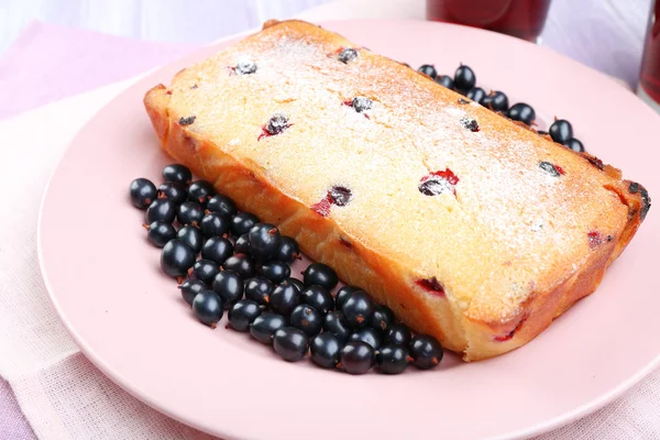 Freshly baked cake with black currants in pink plate, closeup — Stock Photo, Image