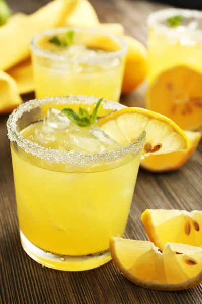 Glasses of lemon juice on wooden table, closeup — Stock Photo, Image