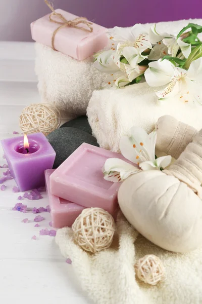Borse da massaggio con trattamento spa e fiori su sfondo tavolo in legno — Foto Stock