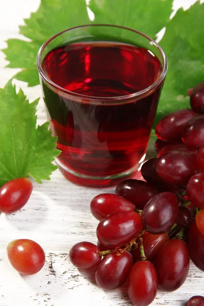 Glass of grape juice on wooden table, closeup — Stock Photo, Image