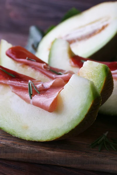 Meloen met prosciutto van parmaham op houten tafel, close-up — Stockfoto