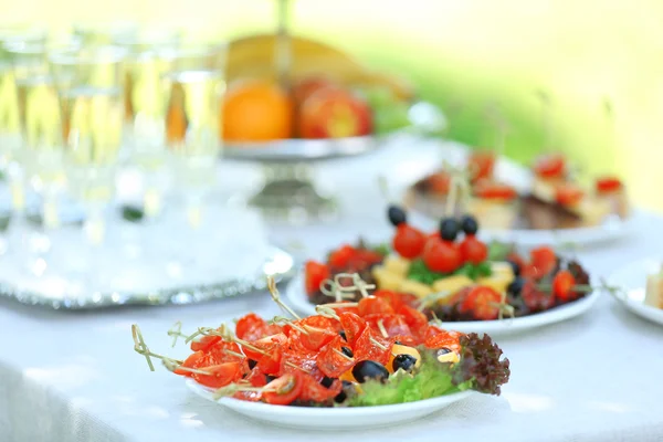 Snacks, frutas y bebidas en la mesa, al aire libre. Jardín concepto de fiesta — Foto de Stock