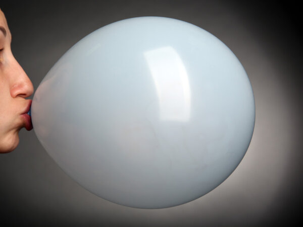 Young woman inflating balloon