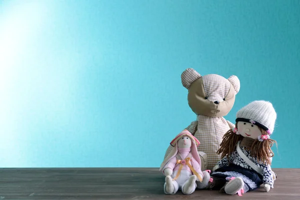 Dolls and teddy bear on blue background — Stock Photo, Image